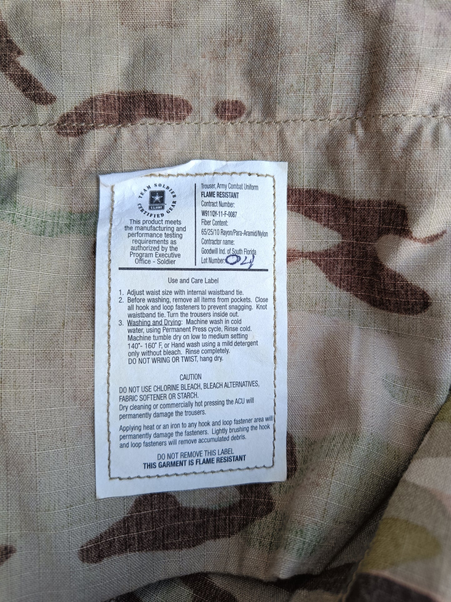 Kalhoty US Army multicam originál - štítek zevnitř kalhot - kde je popsáno, že jsou kalhoty nehořlavé, atd...