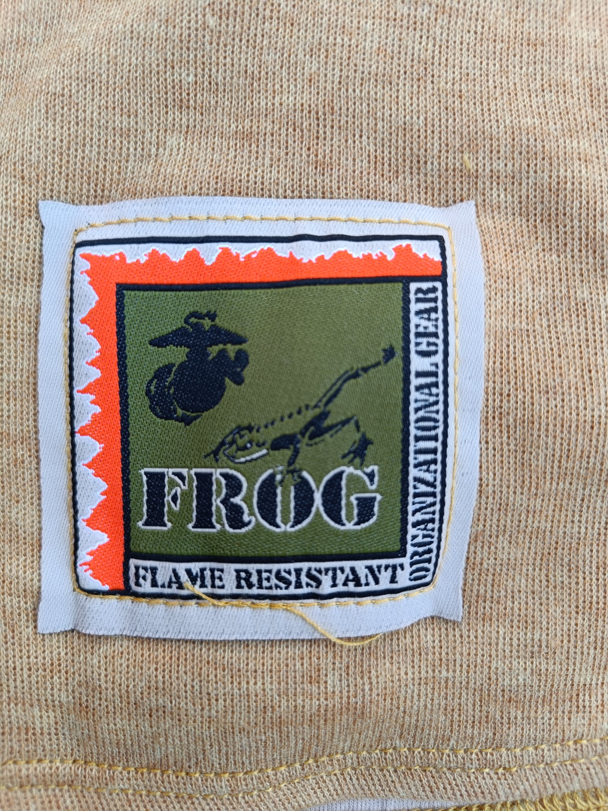 Štítek výrobce FROG a označení "Flame resistant" nehořlavé